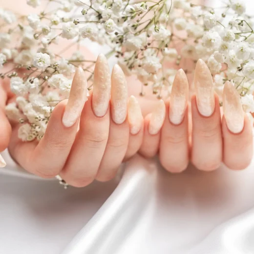 female-hands-white-silk-background-with-beautiful-pearl-manicure-scaled-1.webp